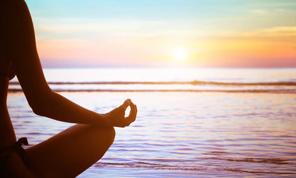 Meditating on the beach at sunset